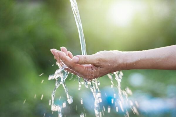 Hand mit einem Wasserstrahl