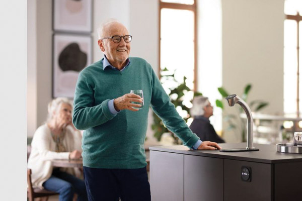Senior steht vor dem Sodamaster 50 von BRITA