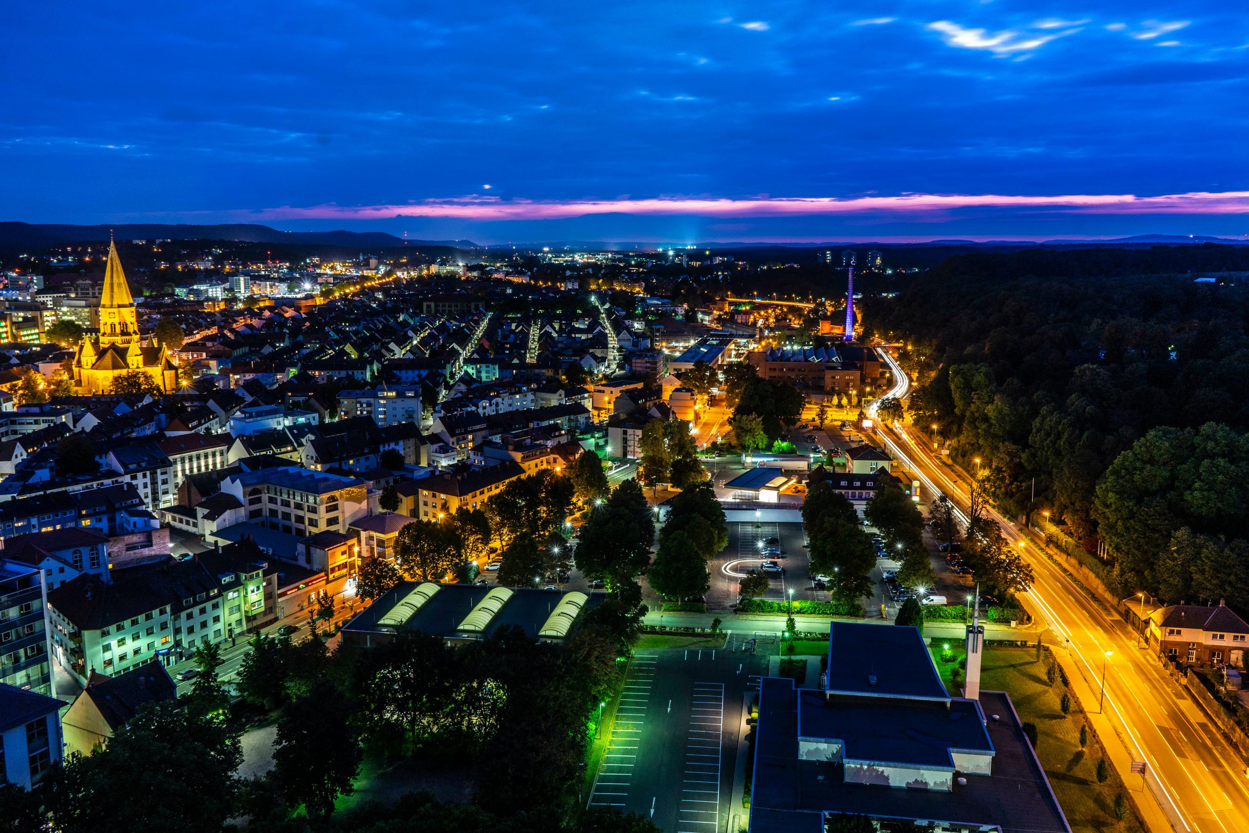 Kaiserlautern bei Nacht aus einer Vogelperspektive. Man sieht viele beleuchtete Straßen und Häuser.