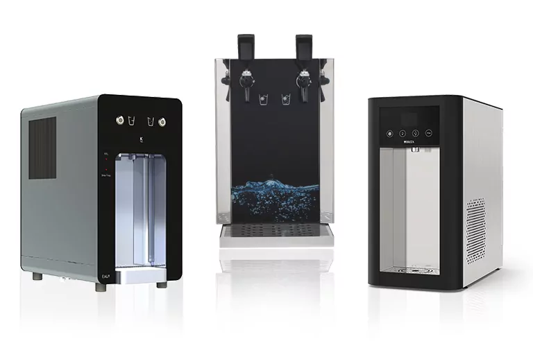 "Das Bild zeigt drei moderne Auftisch-Wasserspender von Jakob Wassertechnik. Auf der linken Seite befindet sich ein kompaktes Gerät mit Glaswasserabgabe, in der Mitte ein eleganter Wasserspender mit mehreren Ausgängen und auf der rechten Seite ein weiteres schlankes Gerät zur Wasserversorgung.