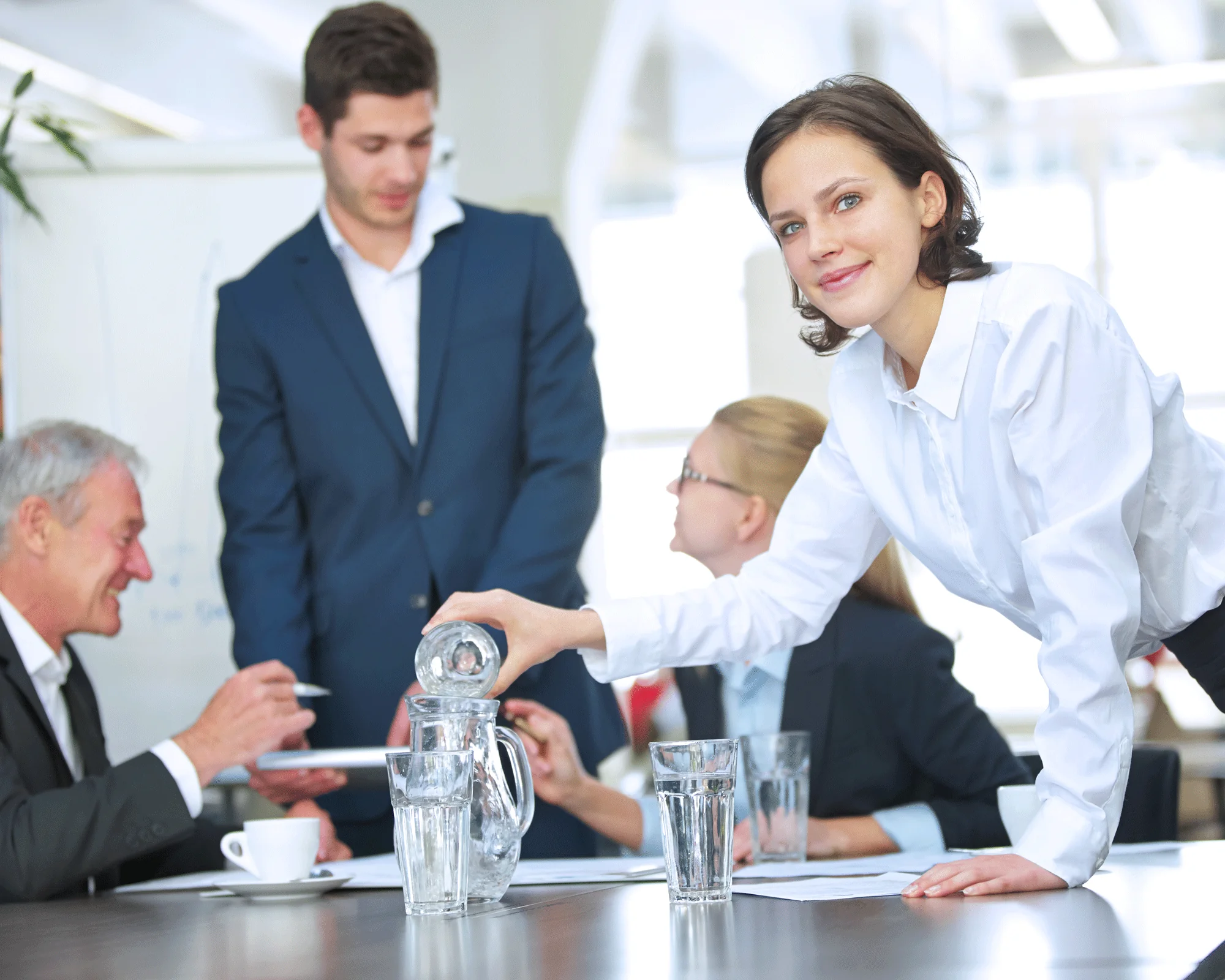 Wasserspender mieten für Büro & Unternehmen – einfach, flexibel und gesund Mitarbeiterin schenkt Wasser im Büro ein – gesundes Trinkverhalten durch gemieteten Wasserspender im Unternehmen fördern